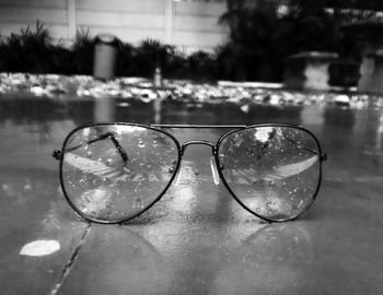 Close-up of sunglasses on water against sky