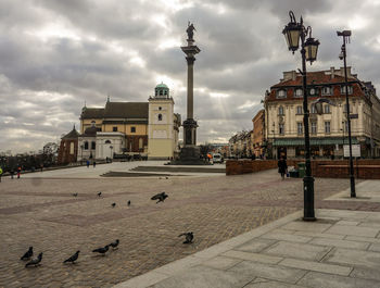 Buildings in city against cloudy sky