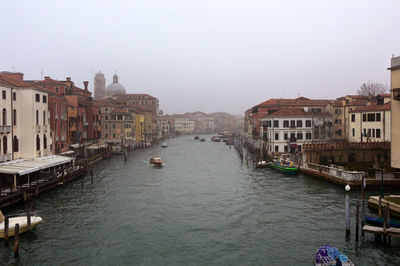 Boats in canal along buildings