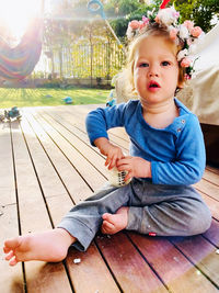 Portrait of cute boy sitting on wood