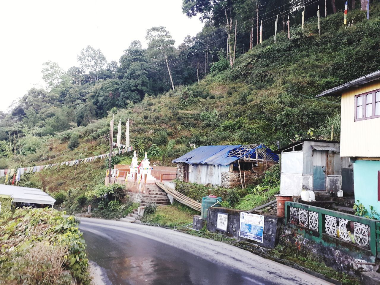 HOUSES BY ROAD AGAINST SKY