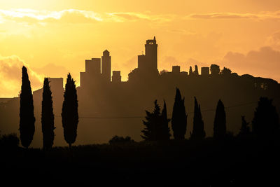 Silhouette of buildings against sky during sunset