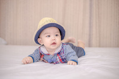 Portrait of cute boy lying on bed