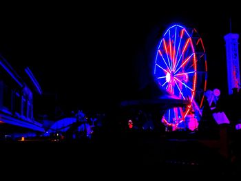 Illuminated ferris wheel at night