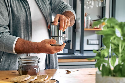 Man preparing classic italian coffee in the mocha in the kitchen. coffee brake. morning habit.