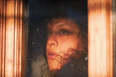 Portrait of woman looking through window