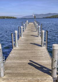 Wooden pier on sea against sky