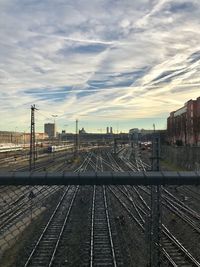 Railroad tracks in city against sky