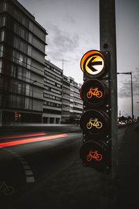 Traffic light on road against buildings in city