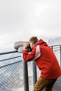 Millennial guy enjoys mountain views of alps from observation deck