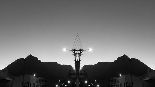 Low angle view of silhouette cranes against sky