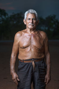 Portrait of shirtless man standing outdoors