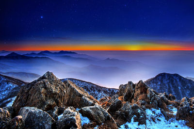 Scenic view of snowcapped mountains against sky at night