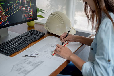 Midsection of woman using laptop on table