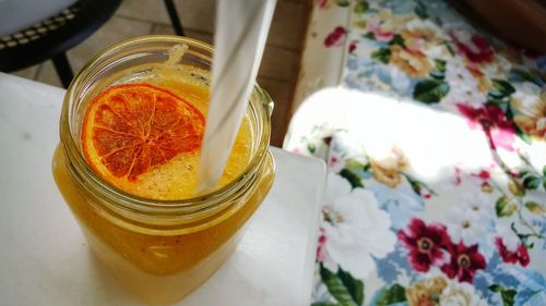 High angle view of orange juice in mason jar on table