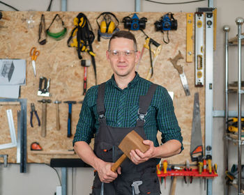 Portrait of young man standing by wall