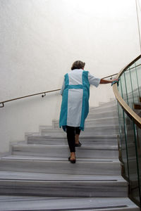 Rear view of woman walking on stairs