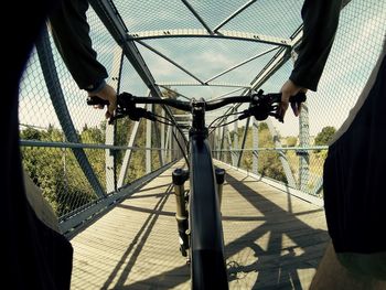 Person riding bicycle on bridge