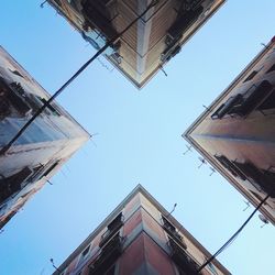 Low angle view of buildings against clear blue sky