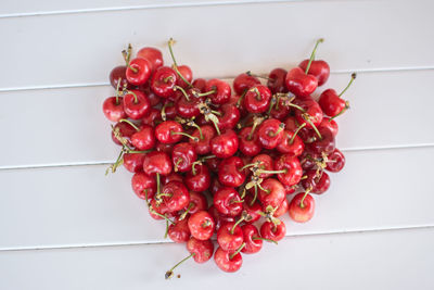 Directly above shot of cherries in heart shape on table