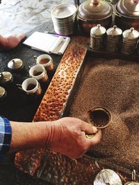 Cropped hand holding container in coffee beans