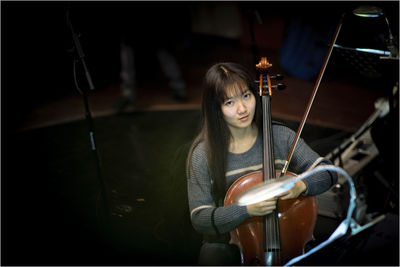 Portrait of beautiful young woman playing guitar