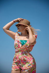 Woman wearing hat against blue sky