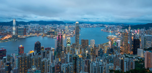 Aerial view of city buildings against cloudy sky