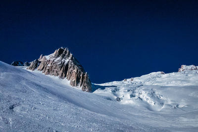 Scenic view of snowcapped mountains against clear blue sky