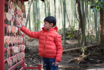 Boy looking at wooden kit rings hanging on rack