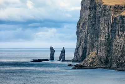 Rock formation in sea against sky