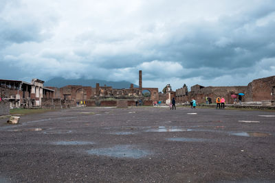 View of buildings in city against cloudy sky