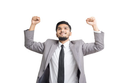 Portrait of young man standing against white background