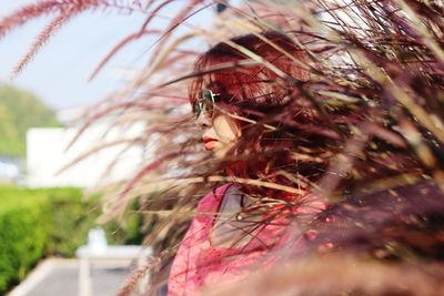Close-up portrait of woman with red leaves
