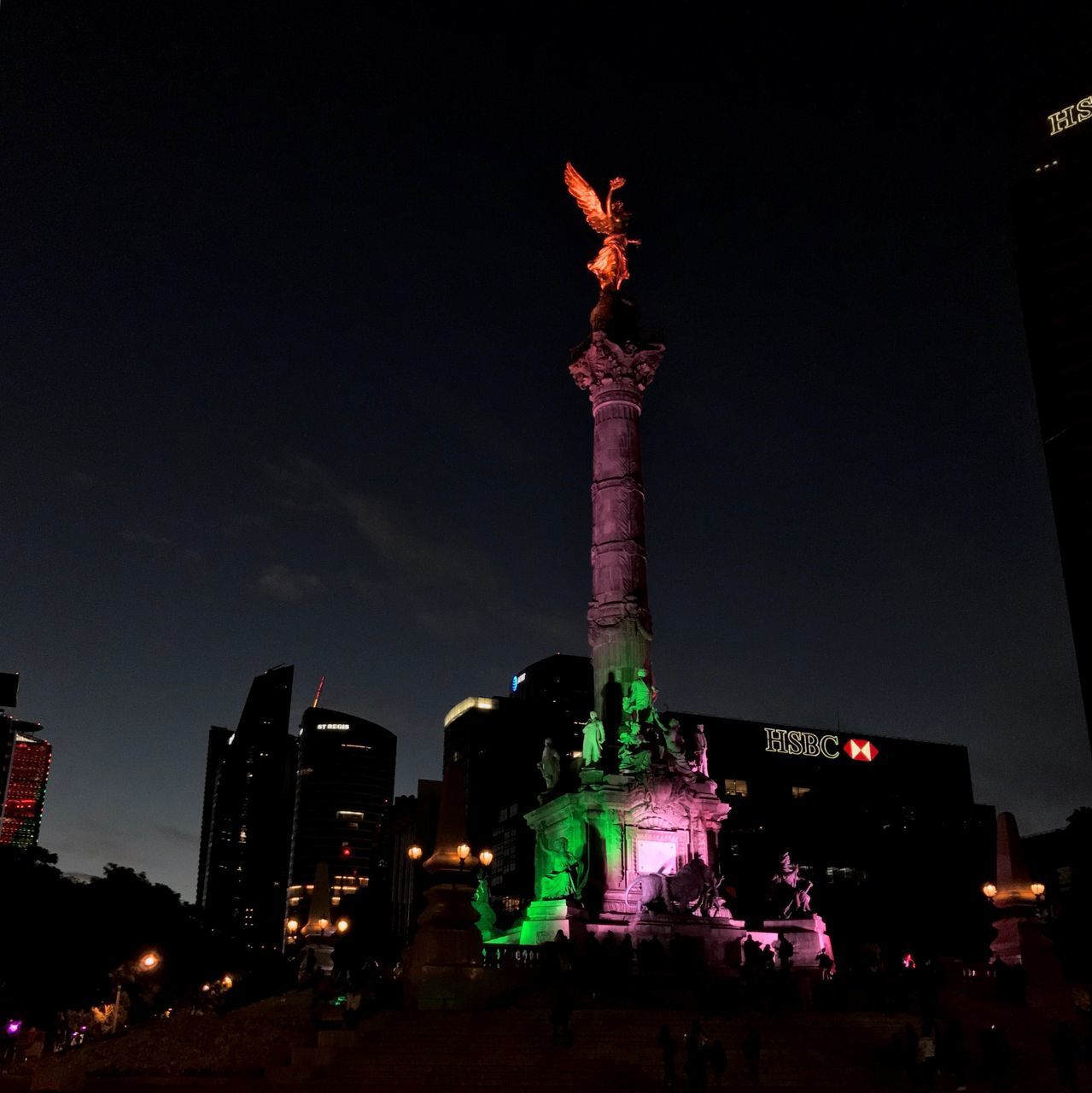 LOW ANGLE VIEW OF STATUE AGAINST ILLUMINATED BUILDINGS