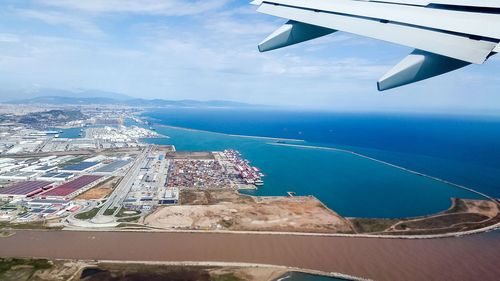Aerial view of city by sea against sky