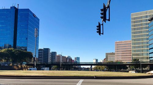 Low angle view of modern buildings against clear blue sky