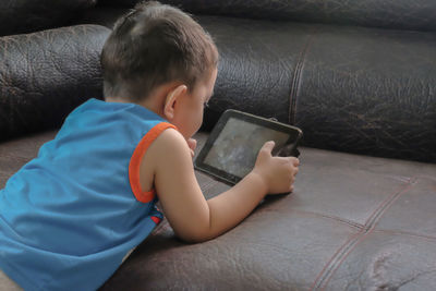 Boy watching video in digital tablet at home