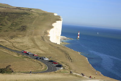 Scenic view of cliff by sea against sky