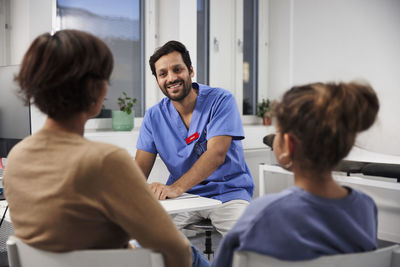 Male doctor talking to mother and daughter during appointment