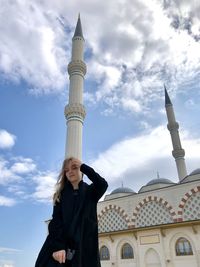 Low angle view of woman against temple building against sky