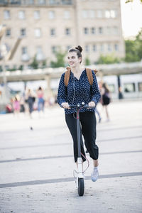 Young woman riding electric scooter in the city