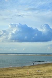 People on beach against sky