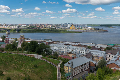 High angle view of townscape by sea against sky