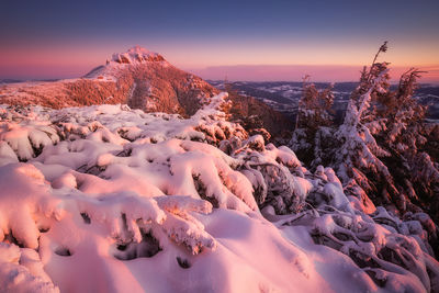 Scenic view of snow mountains against sky during sunset in ceahlau mountains 