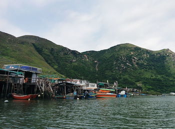 Boats moored on shore against sky