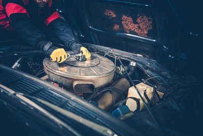 High angle view of man repairing car engine