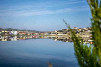 Buildings by sea against blue sky