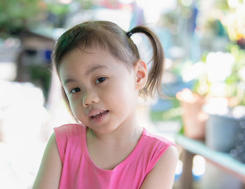 Cute baby asian girl, little preschooler child with adorable ponytails smiling looking at camera.