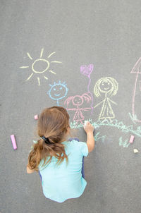 High angle view of girl drawing on road